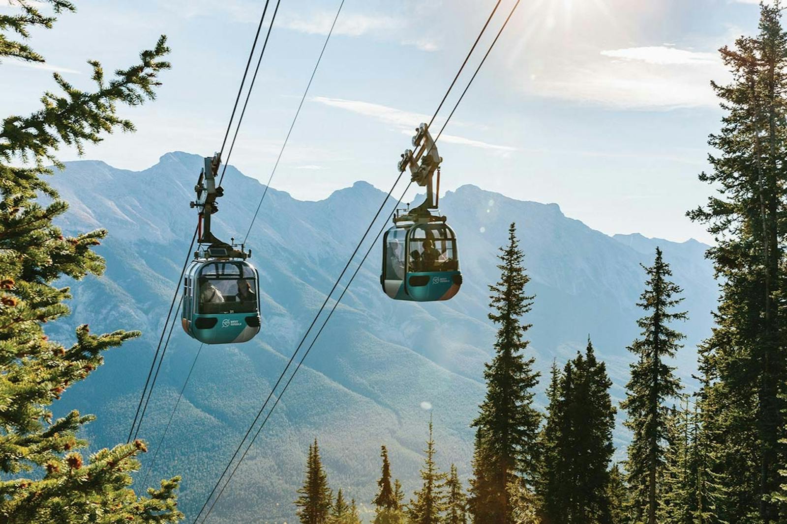 Banff Gondola flyger över bergen under en ljus himmel